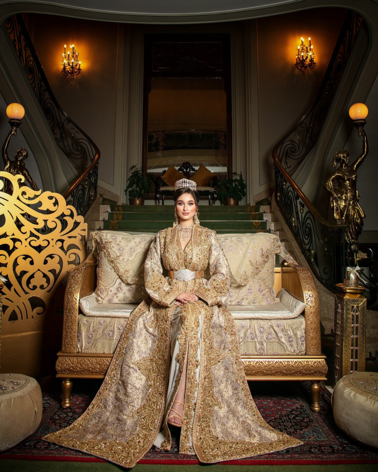 a woman in a gold dress sitting on a couch