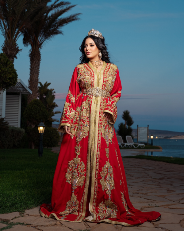 a woman in a red and gold caftan dress