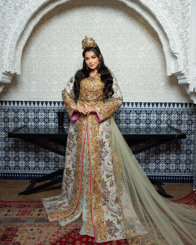 a woman in a gold and white dress caftan